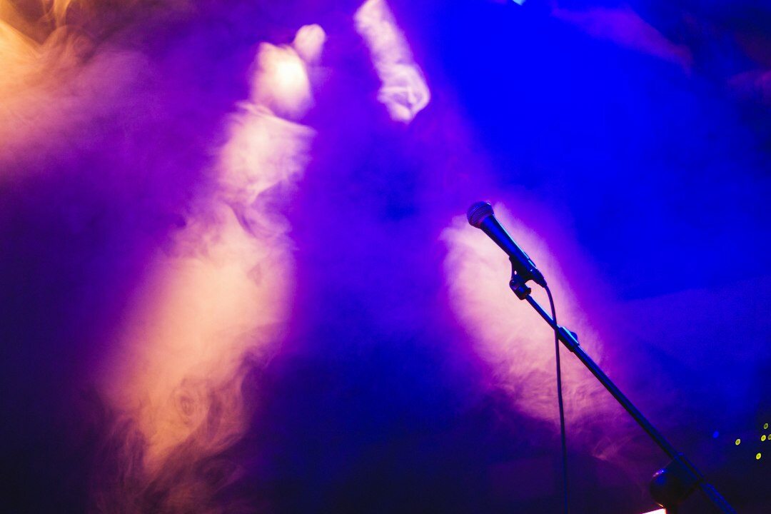 Musician performing on stage with a microphone